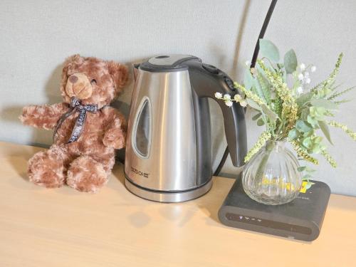 a teddy bear sitting next to a tea kettle at TOP Stay Guro digital complex in Seoul