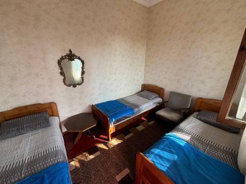 a room with two beds and a chair and a mirror at Tazo's Guest House in K'obulet'i