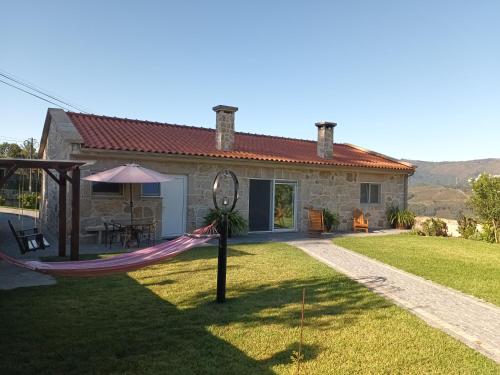 a house with a hammock in the yard at Casa da rosinha - Minho, Portugal in Arcos de Valdevez