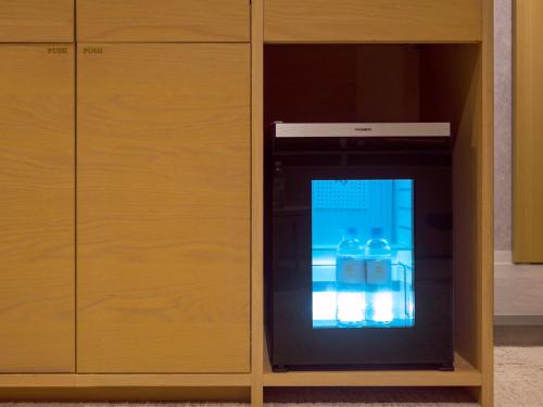 a black appliance in a wooden cabinet at Kumamoto Hotel Castle in Kumamoto