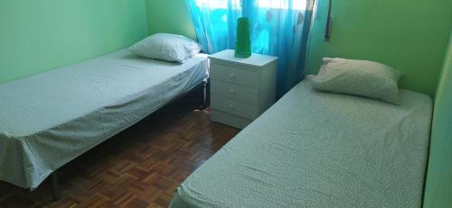 a bedroom with two beds and a tv on a dresser at PISO VINTAGE EN Madrid in Móstoles