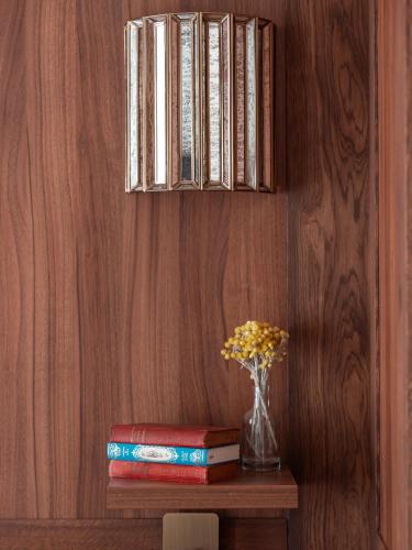 a shelf with books and a vase of flowers on a table at Hotel Madeleine De Senlis in Paris