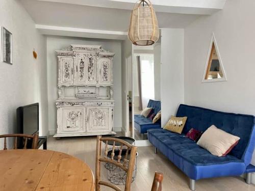 a living room with a blue couch and a table at Fun x Cosy City Retreat by Melrose in Bayeux