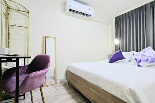 a bedroom with a bed and a table and a mirror at ChiShi House Songkhla in Ban Bang Dan