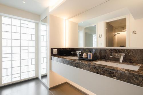 a bathroom with two sinks and a large mirror at YANH Ratchawat Hotel in Bangkok