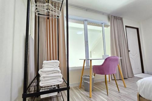 a bedroom with a desk and a purple chair at ChiShi House Songkhla in Ban Bang Dan