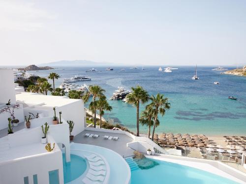 an aerial view of a resort with a pool and the ocean at Mykonos Blu, A Grecotel Resort to Live in Psarou