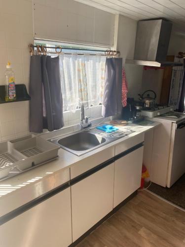 w kuchni z umywalką i oknem w obiekcie Kwatery Prywatne Hotelik w mieście Barczewo
