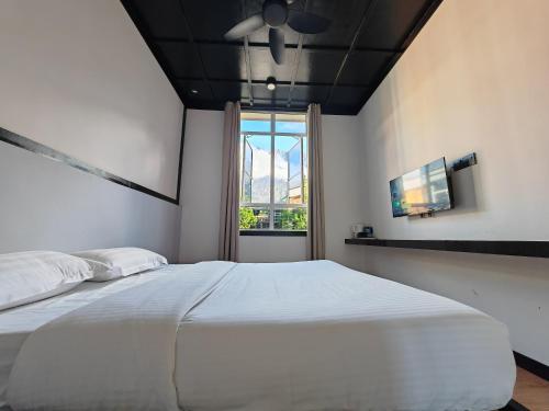 a bedroom with a large white bed and a window at H Benjamin Residence in Kundasang