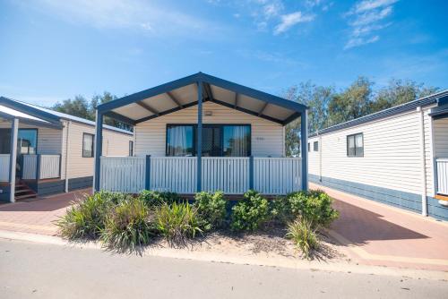 a home with a blue and white building at Jurien Bay Tourist Park in Jurien Bay