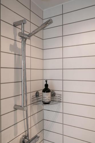 a shower with a bottle of soap on a glass shelf at The Pier Penthouse by Daniel&Jacob's in Copenhagen