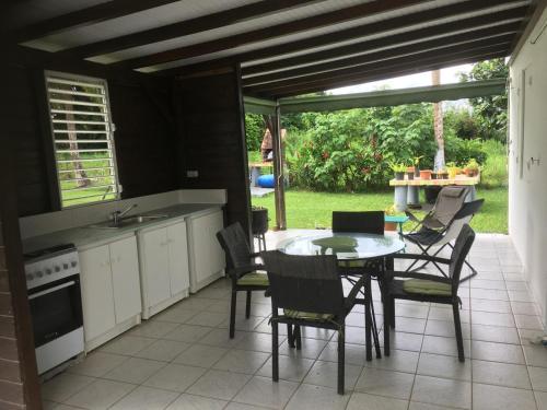 a kitchen with a table and chairs and a kitchen with a view at Dans un coin de verdure in Lamentin