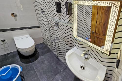 a bathroom with a sink and a toilet and a mirror at Blissful Stay, LUX Suites & Tint of Mint - 1 BHK Apartment, 5min Beach, Auroville Pondicherry in Kottakupam