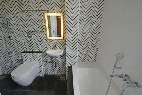 a bathroom with a sink toilet and a mirror at Blissful Stay, LUX Suites & Tint of Mint - 1 BHK Apartment, 5min Beach, Auroville Pondicherry in Kottakupam