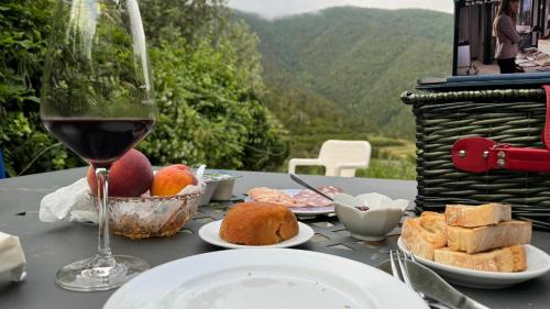 a table with a glass of wine and food on it at Cinque Terre - House & Garden Paradise in Volastra