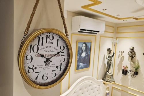 a clock hanging on a wall in a room at Blissful Stay, LUX Suites & Tint of Mint - 1 BHK Apartment, 5min Beach, Auroville Pondicherry in Kottakupam
