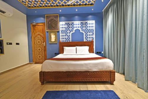 a bedroom with a bed and a blue wall at Blissful Stay, LUX Suites & Tint of Mint - 1 BHK Apartment, 5min Beach, Auroville Pondicherry in Kottakupam