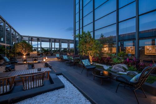 a rooftop patio of a building with tables and chairs at UrCove by Hyatt Shenzhen Bay Nanyou in Shenzhen