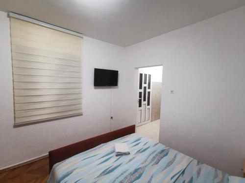 a bedroom with a bed and a flat screen tv at Bar-Apartman 2 in Bar