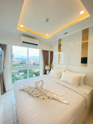 a bedroom with a large white bed with a large window at Empire Tower Pattaya Jomtien Beach in Jomtien Beach