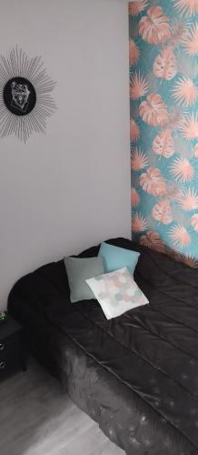 - un lit noir dans une chambre avec un mur dans l'établissement L Éclipse, à Aix-les-Bains