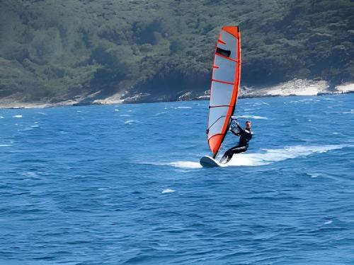 a man windsurfing in the ocean on the water at Summer Park Residence Peljesac in Orebić