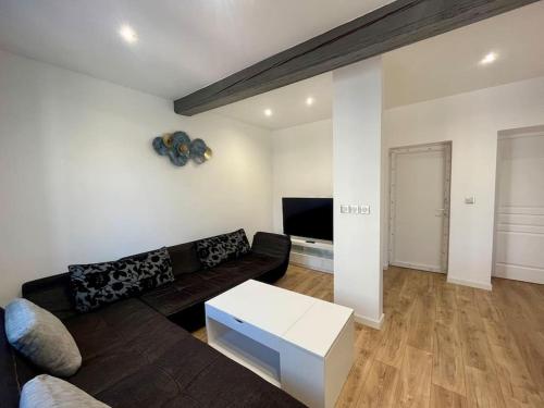 ein Wohnzimmer mit Couch und Tisch in der Unterkunft T2 rénové à 15 min de Lyon in Pierre-Bénite