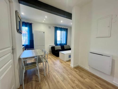 ein Wohnzimmer mit Tisch und Couch in der Unterkunft T2 rénové à 15 min de Lyon in Pierre-Bénite