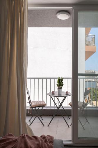 a view of a balcony with a table and chairs at Modern 2BR Apartment with Outside Furniture - Close to Sliema, Saint Julians & Valletta in Msida