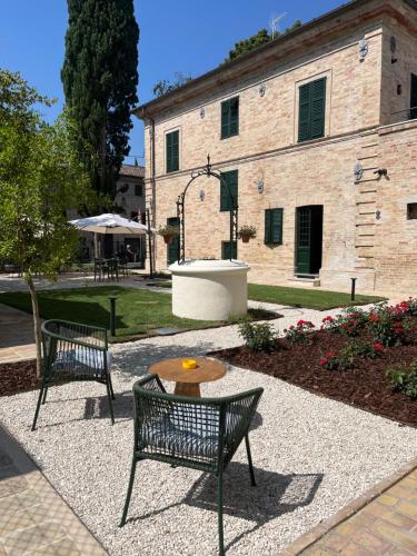 two benches and a table in front of a building at Bed and Breakfast Casa Castelli - ospitalità e vino in Falerone