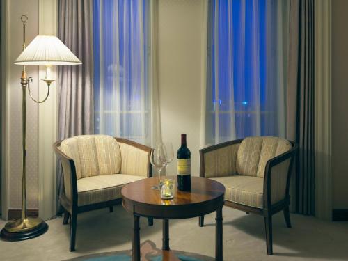 a living room with two chairs and a table with a bottle of wine at Kumamoto Hotel Castle in Kumamoto