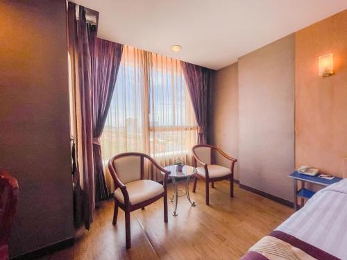 a room with two chairs and a table and a window at Eastern Grand Palace in Pattaya South