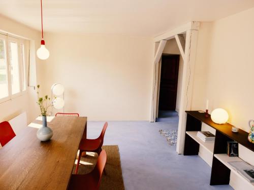 a dining room with a wooden table and chairs at Confort et calme à moins de 2h de Paris in Boudernault