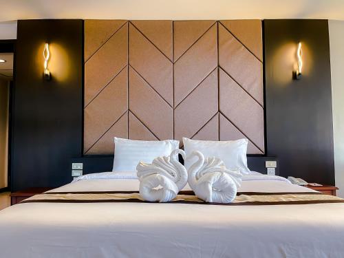 a bedroom with a bed with two white towels at Eastern Grand Palace in Pattaya South
