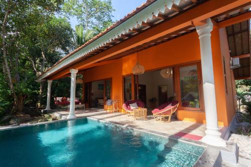 a house with a swimming pool in front of a house at Darmada Eco Resort in Sidemen