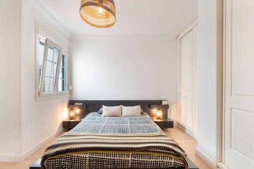 a bedroom with a large bed with two lamps at La casa de los viajeros in Punta del Hidalgo