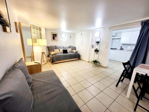 a living room with a couch and a table at J1 St-Quentin-en -Yvelines Studio en Rez de jardin avec parking in Trappes
