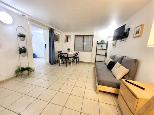 un salon avec un canapé et une table dans l'établissement J1 St-Quentin-en -Yvelines Studio en Rez de jardin avec parking, à Trappes