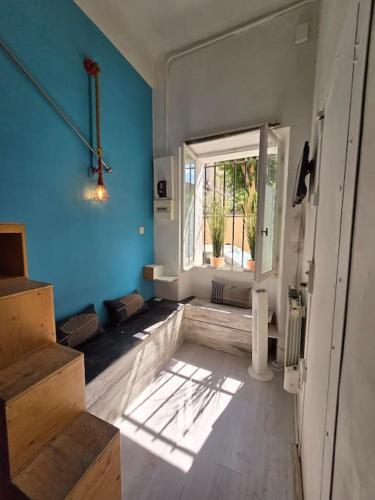 Cette chambre est dotée d'un mur bleu, d'une fenêtre et d'escaliers. dans l'établissement Studio Cosy Longchamps Centre Ville, à Marseille