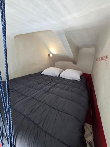 - un lit dans une petite chambre avec 2 oreillers dans l'établissement Studio Cosy Longchamps Centre Ville, à Marseille