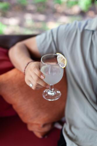 a person holding a glass with a lemon on it at Darmada Eco Resort in Sidemen