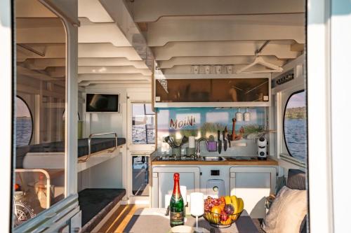 a kitchen in an rv with a table with food at Hausboot als Festlieger im Hafen -Hafenruhe- in Braunsbedra