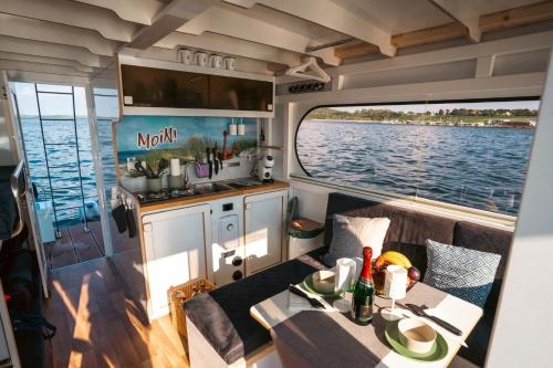 a kitchen and a table on a boat at Hausboot als Festlieger im Hafen -Hafenruhe- in Braunsbedra