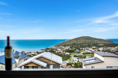 a bottle of wine in a window with a view of the ocean at Seaview at the Bay - Wi-Fi - Oceanview - Near Beach - No Linen Included in Encounter Bay