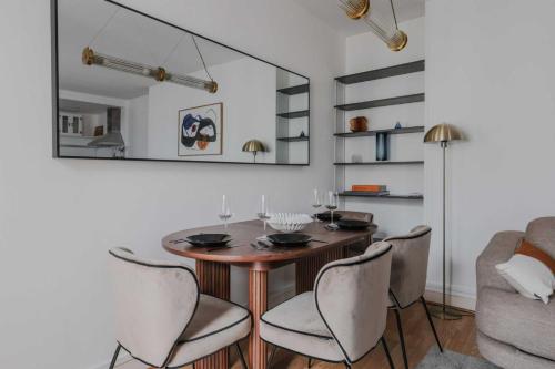 une salle à manger avec une table, des chaises et un miroir dans l'établissement Quiet apartment -1BR-4P - Neuilly-sur-Seine, à Neuilly-sur-Seine