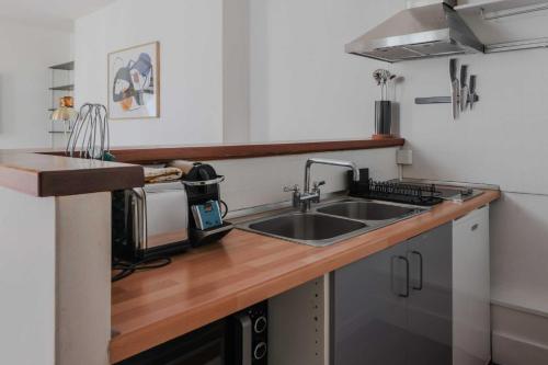 une cuisine avec un évier et un plan de travail en bois dans l'établissement Quiet apartment -1BR-4P - Neuilly-sur-Seine, à Neuilly-sur-Seine