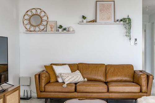 a living room with a brown leather couch at Seaview at the Bay - Wi-Fi - Oceanview - Near Beach - No Linen Included in Encounter Bay