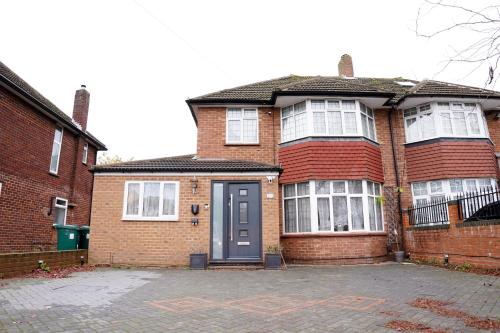 a red brick house with a blue door at Cosy 1 Bed-Flat with Patio Near Heathrow in Stanwell