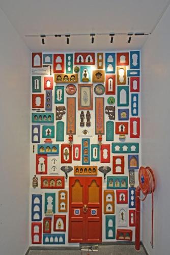 a wall in a room with a wall covered in magnets at Blissful Stay, LUX Suites & Tint of Mint - 1 BHK Apartment, 5min Beach, Auroville Pondicherry in Kottakupam