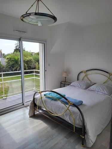 une chambre avec un lit et une grande fenêtre dans l'établissement VILLA FAMILIALE Bord de Mer, à Beg-Meil